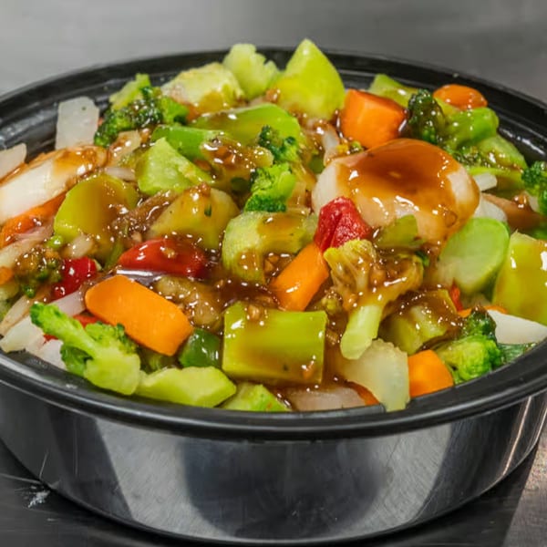 Kona Charli's Hawaiian chicken and vegetable stir-fry with a savory sauce in a black bowl.